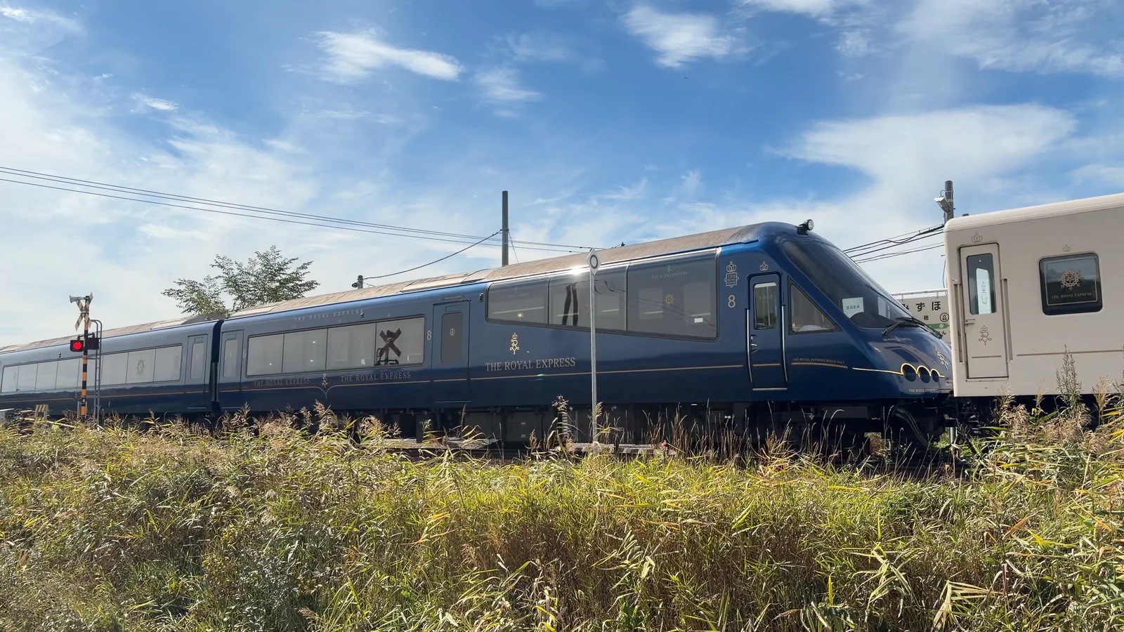 瑞穂駅を北へ通過する深い青色のTHE ROYAL EXPRESS先頭車