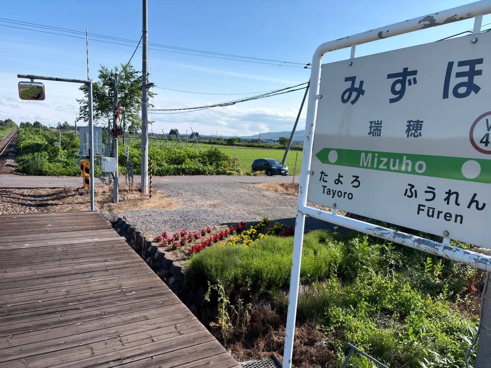 夏の瑞穂駅の駅名標と花壇
